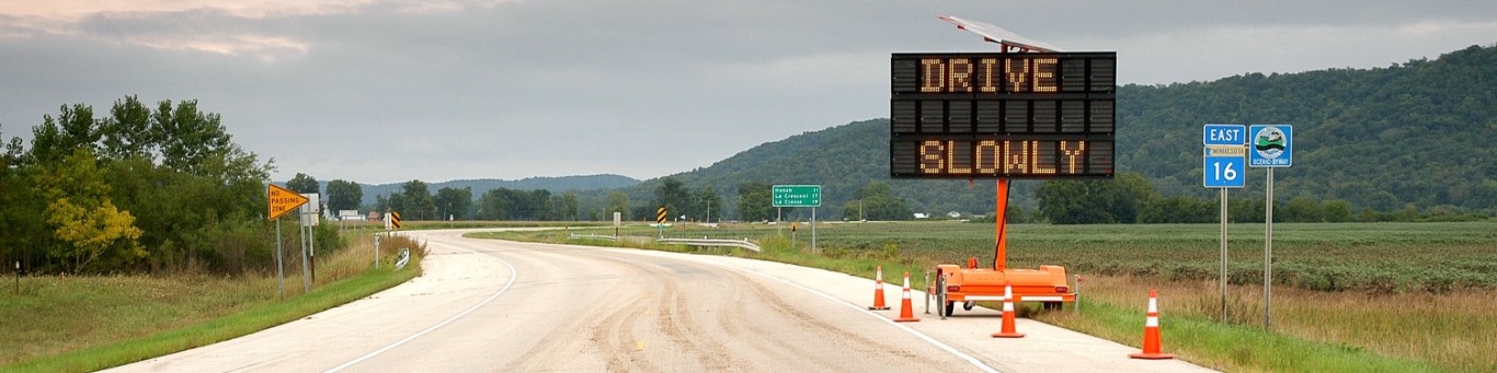 road under construction with drive slowly sign